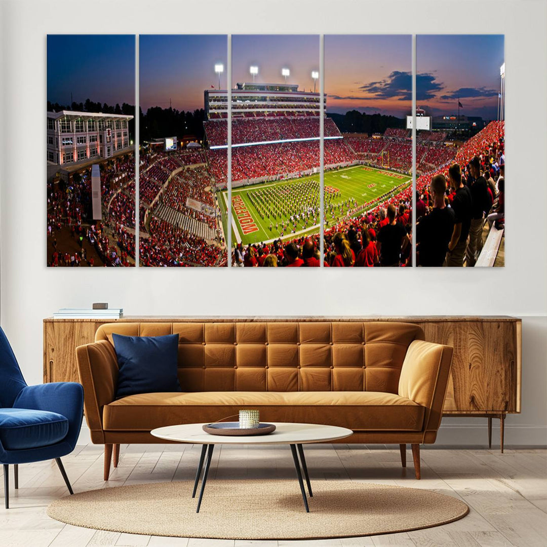 A print of a bustling Carter-Finley Stadium at dusk, featuring fans and a band, captures the essence of NC State Wolfpack football.