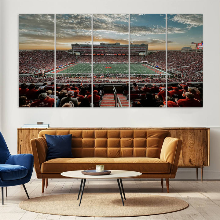 The living room features a stunning triptych of Lincoln Memorial Stadium wall art canvas print, celebrating the University of Nebraska Cornhuskers football team. This piece serves as captivating wall art, showcasing a gallery-quality finish.