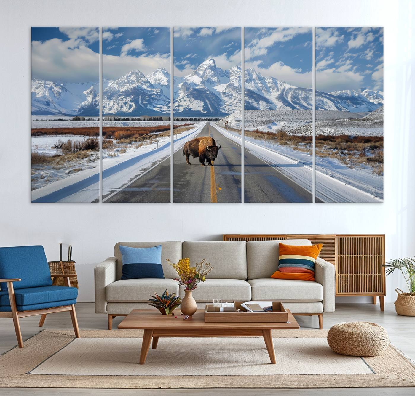 A powerful bison stands on a snow-dusted road beneath the towering peaks of the Grand Tetons, capturing the untamed beauty of America's winter wilderness.