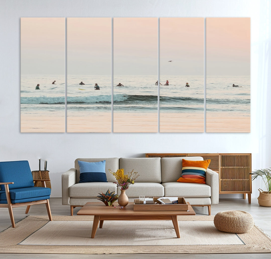 Dreamy photo of surfers waiting on soft pastel waves under a pink sunset sky, ideal for soft coastal minimalist or serene ocean-themed home decor.