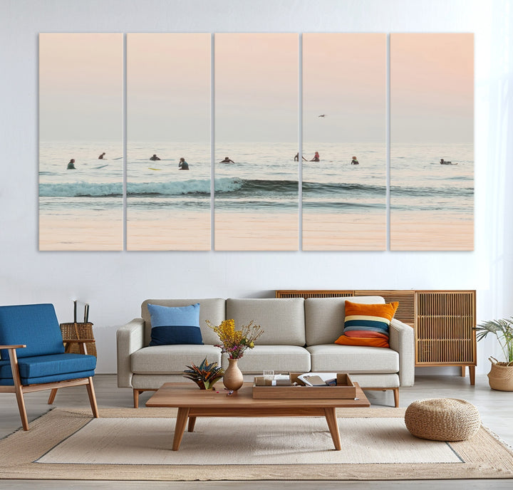 Dreamy photo of surfers waiting on soft pastel waves under a pink sunset sky, ideal for soft coastal minimalist or serene ocean-themed home decor.