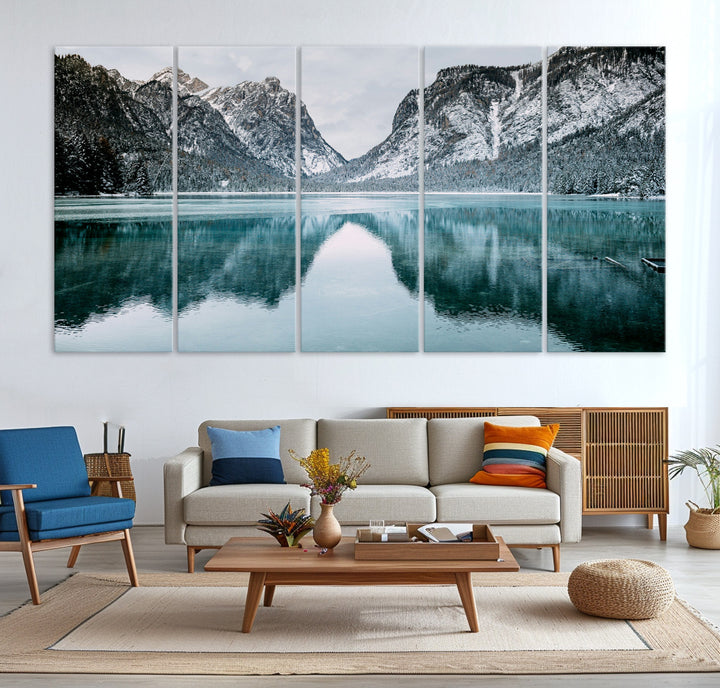 Crystal-clear alpine lake reflecting snow-covered mountains, surrounded by evergreen trees, creating a serene and tranquil winter landscape.
