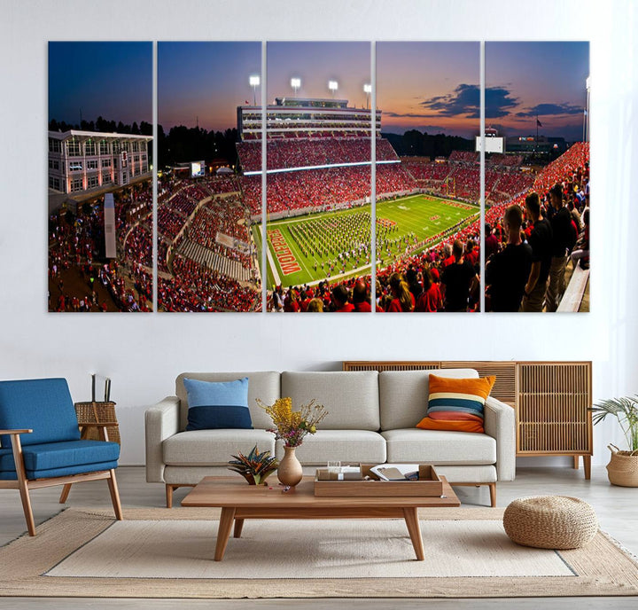 A print of a bustling Carter-Finley Stadium at dusk, featuring fans and a band, captures the essence of NC State Wolfpack football.