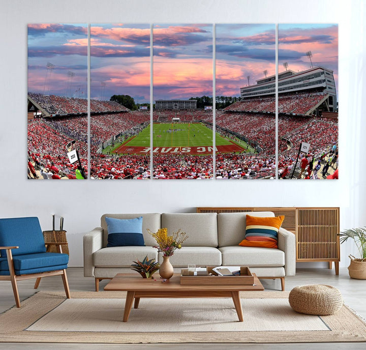 The wall art captures an NC State Wolfpack game under a vibrant sunset on triple canvas.