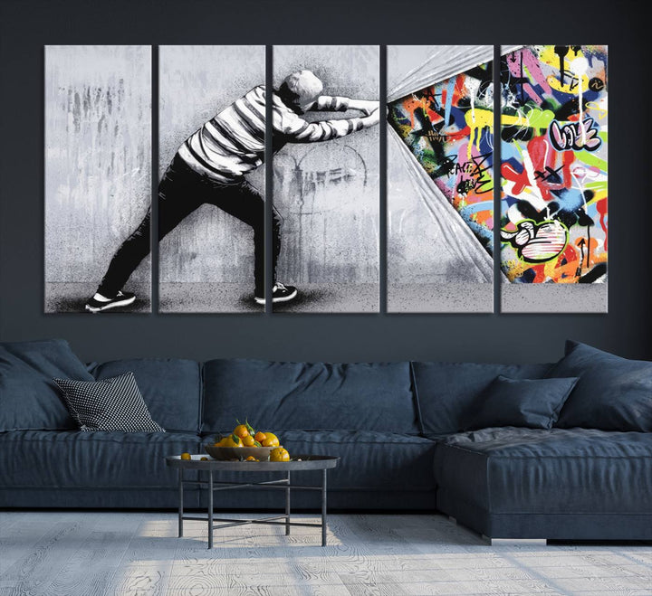 A 3-panel print of Banksys Art Behind the Curtain reveals colorful graffiti beneath a peeling wall.