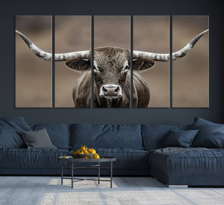 A close-up of a longhorn bull facing forward is featured in the Framed Texas Test-1, set against a blurred brown background.