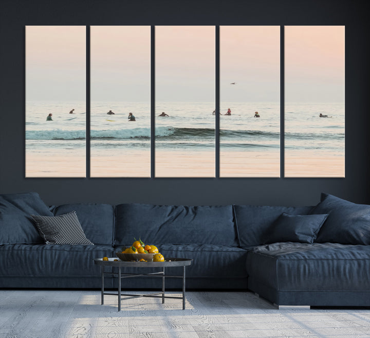 Dreamy photo of surfers waiting on soft pastel waves under a pink sunset sky, ideal for soft coastal minimalist or serene ocean-themed home decor.