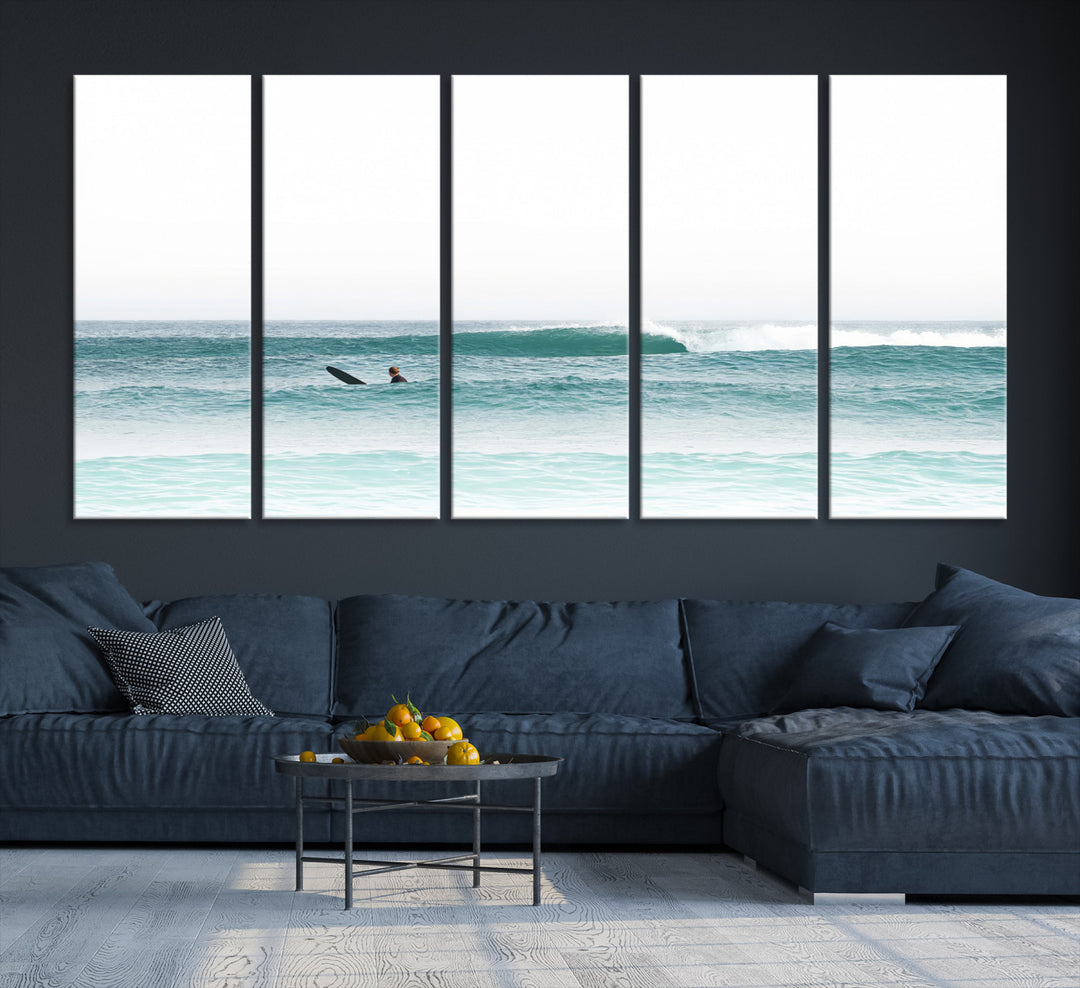 Minimalist photo of a lone surfer on calm aqua waves under bright sky, perfect for Scandinavian coastal or serene ocean-inspired home decor.