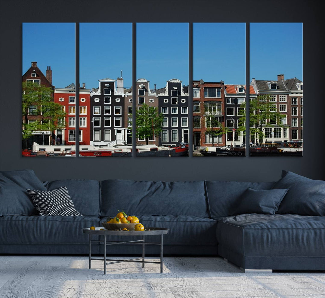 The Amsterdam City Wall Art Canvas Print showcases colorful traditional canal houses and boats set against a clear blue sky.