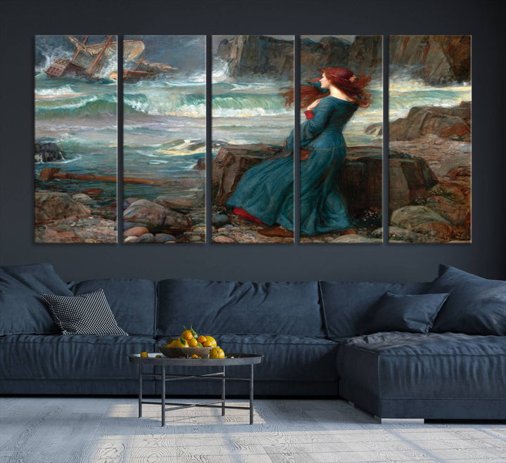 The Miranda by the Shore Wall Art Canvas Print depicts a woman in a blue dress standing by the sea, watching a shipwreck.