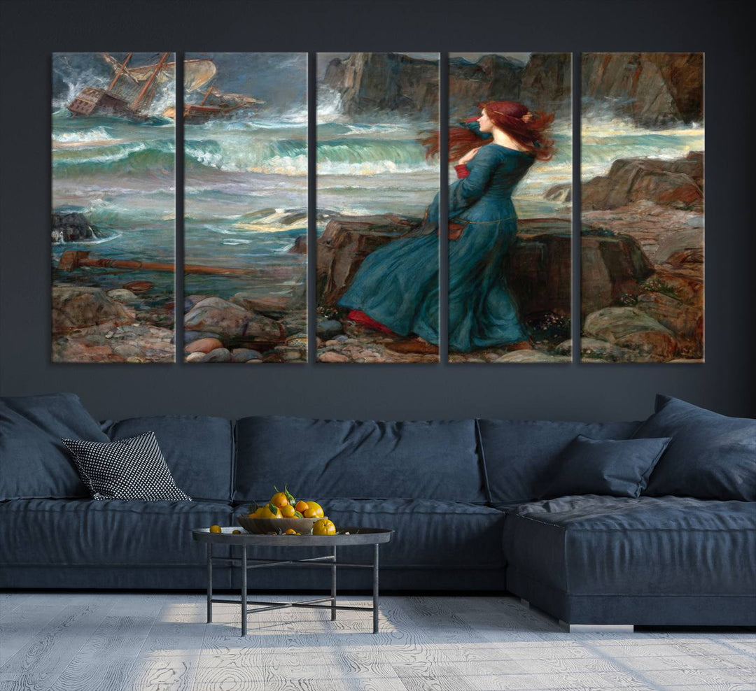 Miranda - The Tempest Canvas Print depicts a woman in a blue dress gazing at a shipwreck on a rocky shore. The artwork is ready to hang.