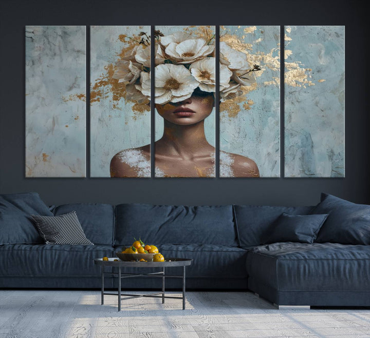 The Golden Petal Silhouette Woman Wall Art Canvas Print, a large 3-panel canvas with a textured gold floral design, serves as a luxurious centerpiece in modern glam settings. The artwork depicts a woman with flowers over her eyes against a textured background and hangs elegantly.