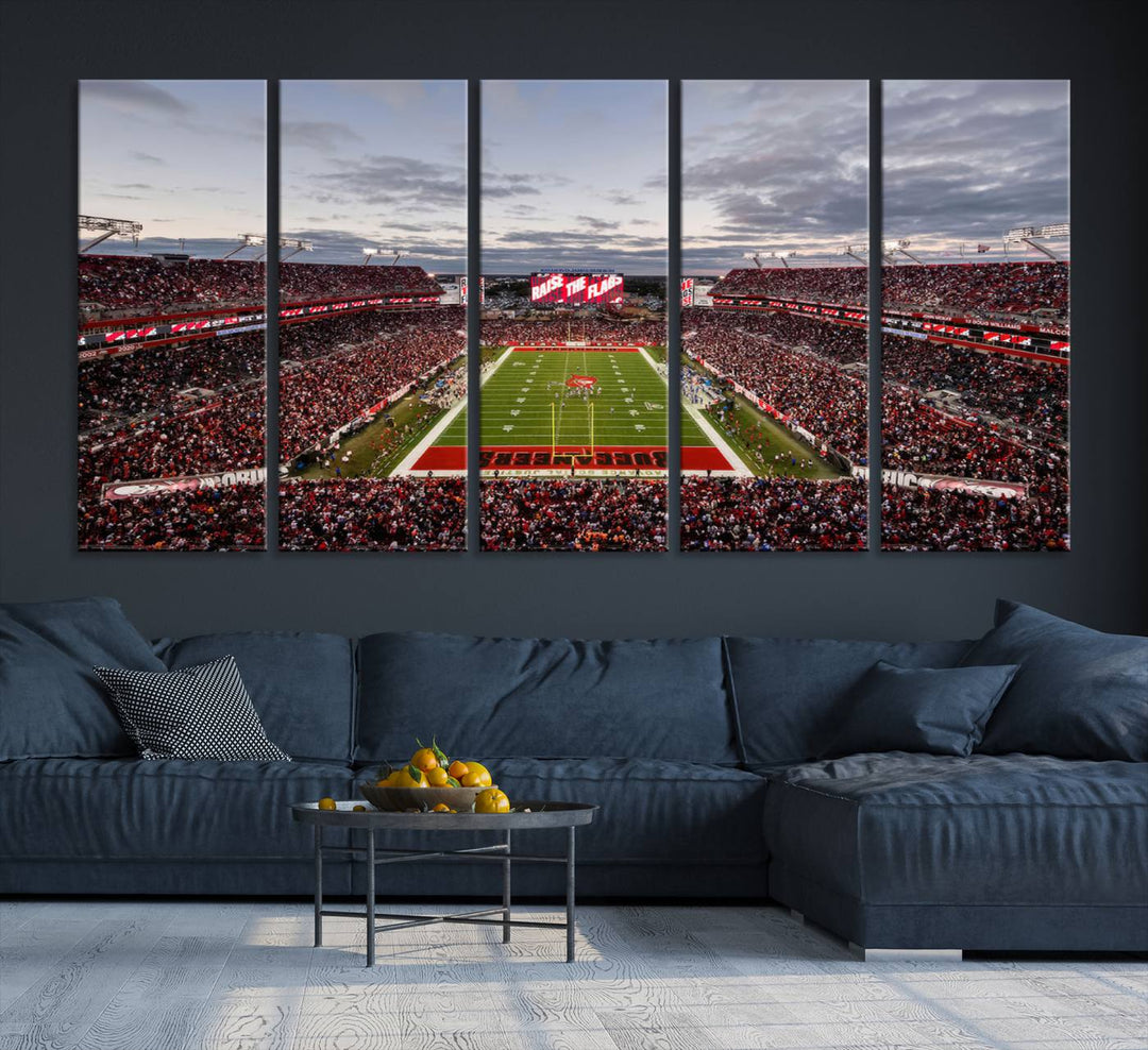 The wall art captures a stunning scene of Raymond James Stadium bathed in the warm hues of sunset. The sky, filled with clouds, provides a dramatic contrast to the vibrant lighting on the field, encapsulating the dynamic energy of a football game.