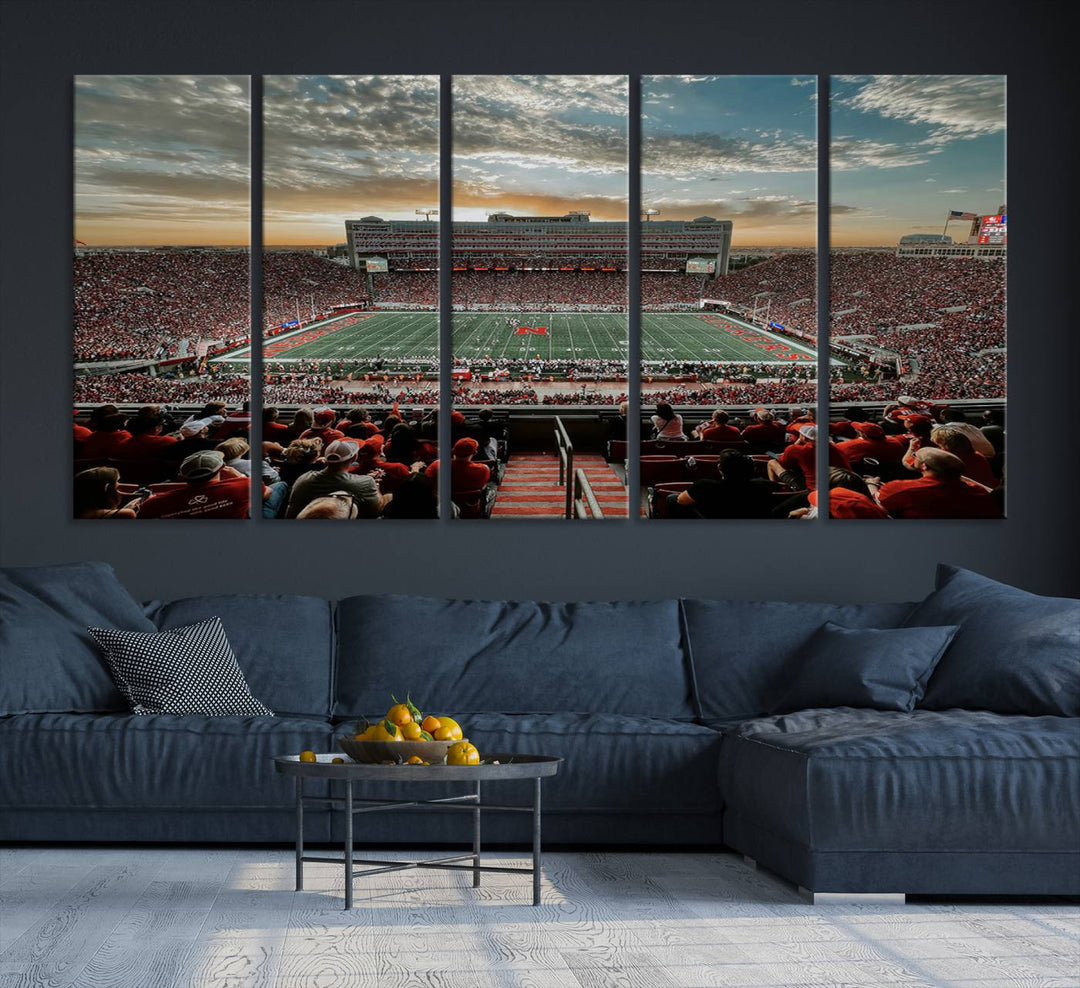 The living room features a stunning triptych of Lincoln Memorial Stadium wall art canvas print, celebrating the University of Nebraska Cornhuskers football team. This piece serves as captivating wall art, showcasing a gallery-quality finish.