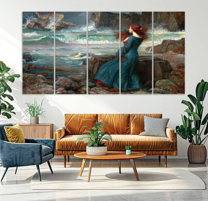 The Miranda by the Shore Wall Art Canvas Print depicts a woman in a blue dress standing by the sea, watching a shipwreck.