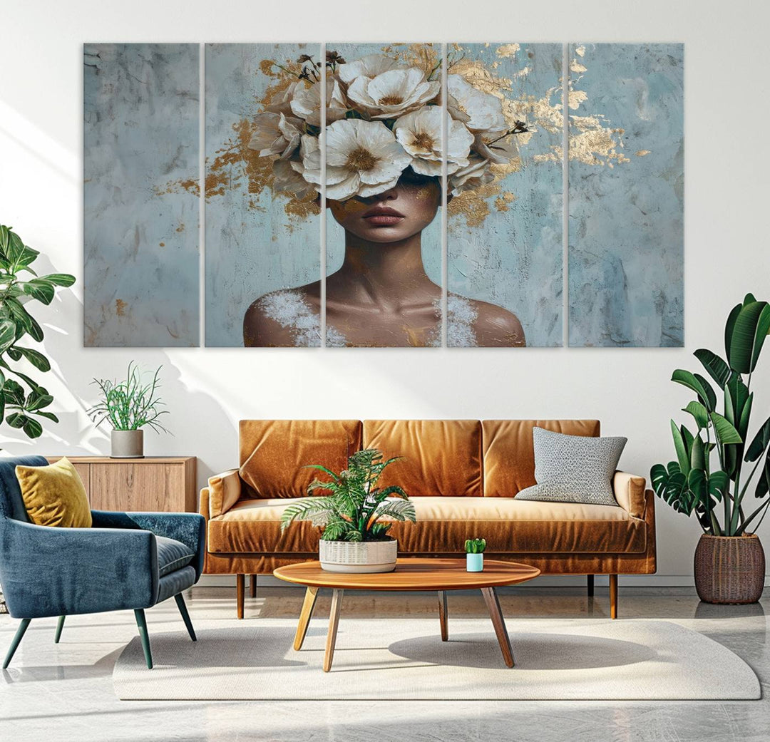 The Golden Petal Silhouette Woman Wall Art Canvas Print, a large 3-panel canvas with a textured gold floral design, serves as a luxurious centerpiece in modern glam settings. The artwork depicts a woman with flowers over her eyes against a textured background and hangs elegantly.