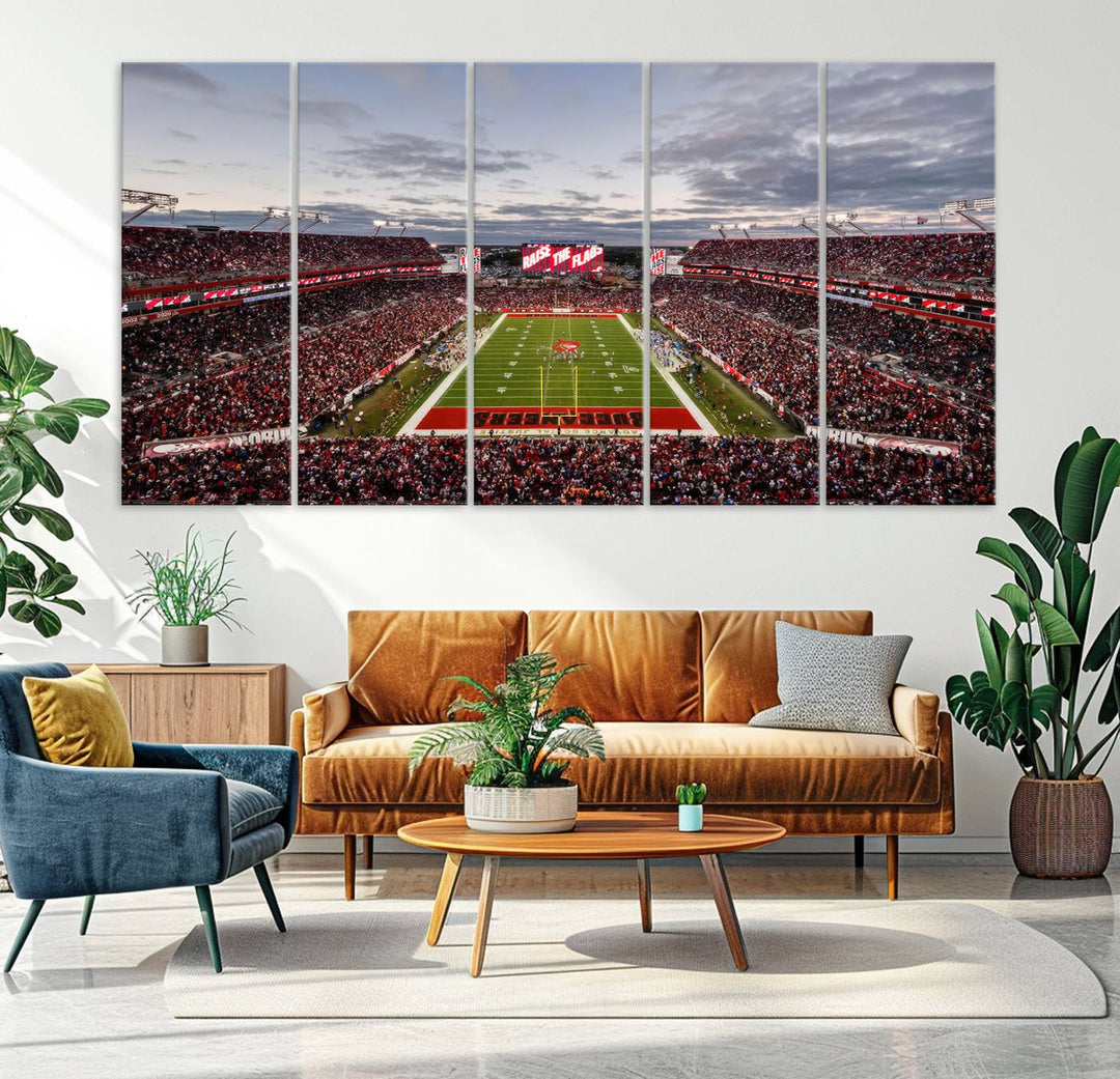 The wall art captures a stunning scene of Raymond James Stadium bathed in the warm hues of sunset. The sky, filled with clouds, provides a dramatic contrast to the vibrant lighting on the field, encapsulating the dynamic energy of a football game.