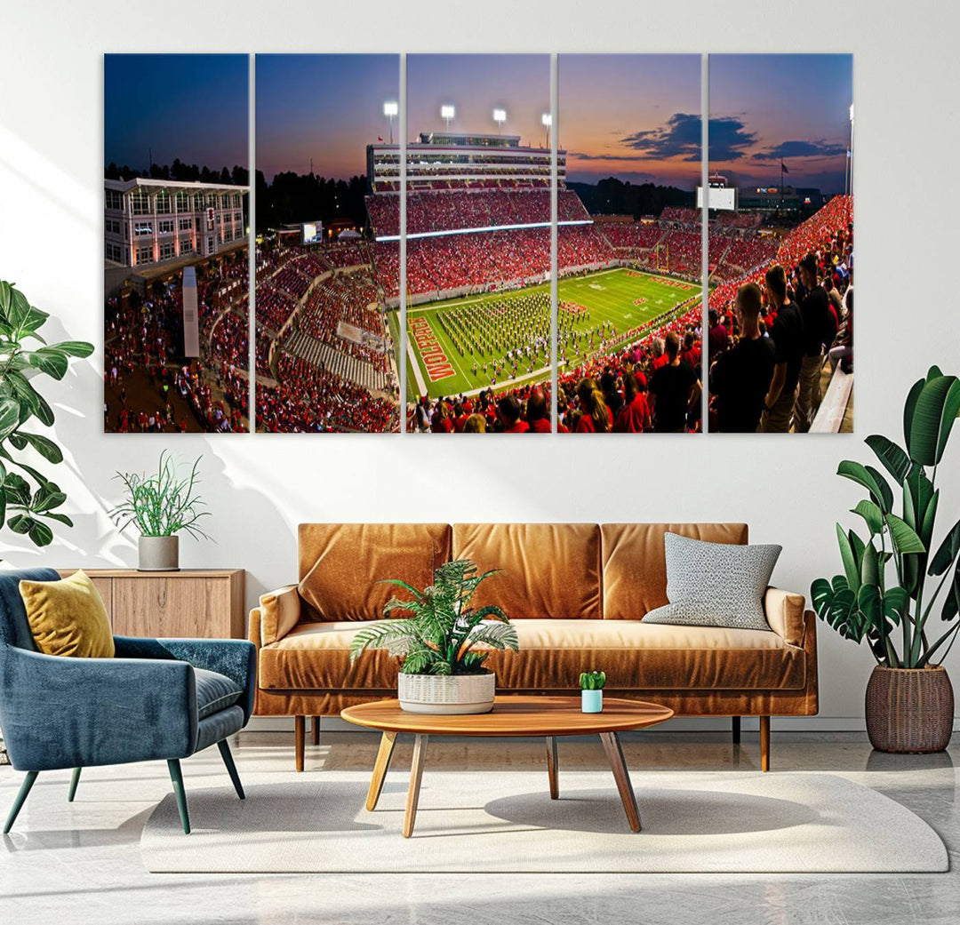 A print of a bustling Carter-Finley Stadium at dusk, featuring fans and a band, captures the essence of NC State Wolfpack football.