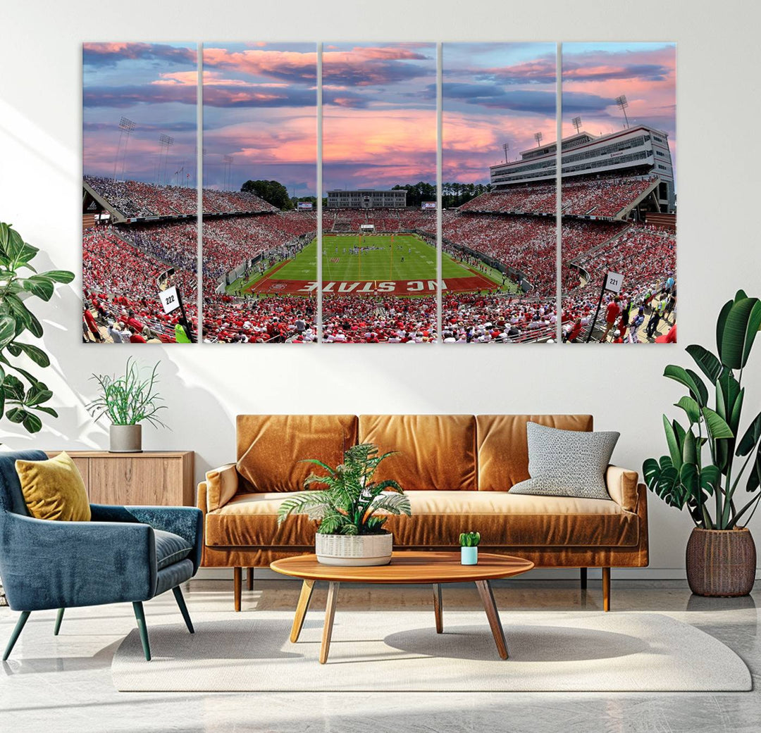 The wall art captures an NC State Wolfpack game under a vibrant sunset on triple canvas.