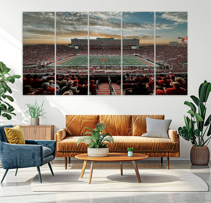 The living room features a stunning triptych of Lincoln Memorial Stadium wall art canvas print, celebrating the University of Nebraska Cornhuskers football team. This piece serves as captivating wall art, showcasing a gallery-quality finish.