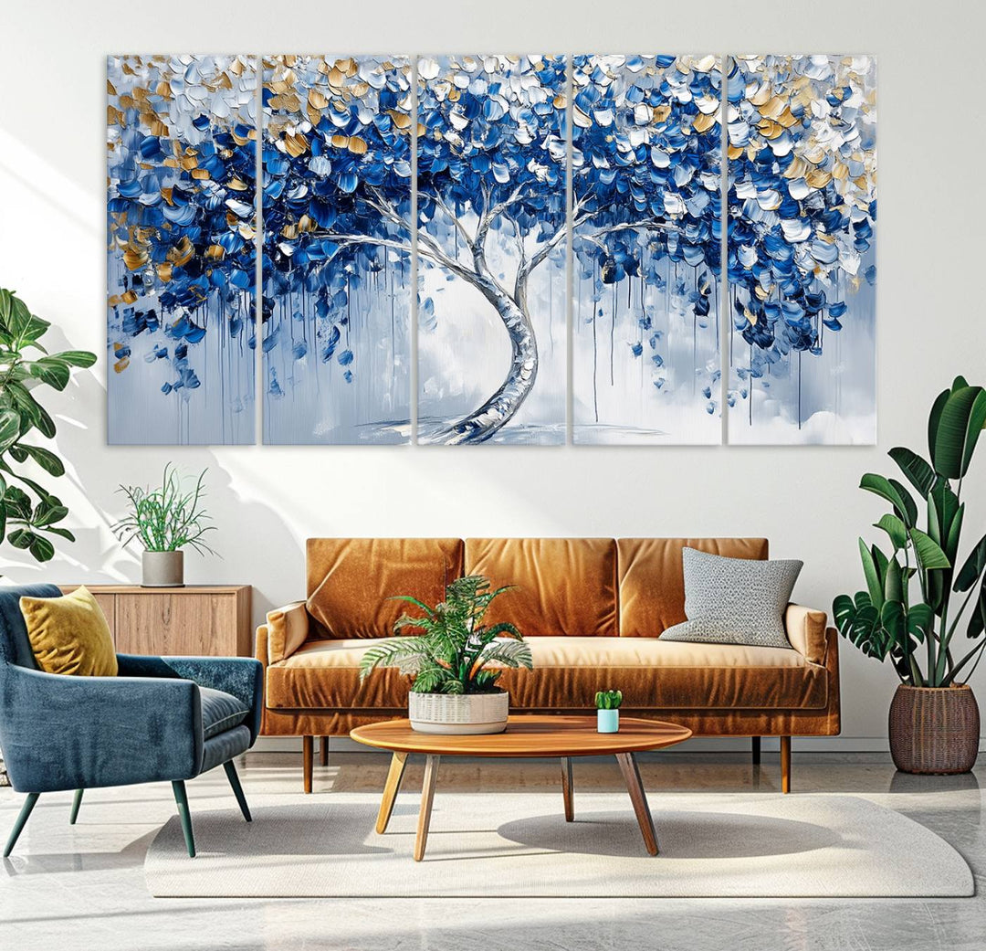 The Blue and Gold Abstract Tree Wall Art showcases a swirl trunk and features blue, silver, and gold leaves on a framed canvas print.