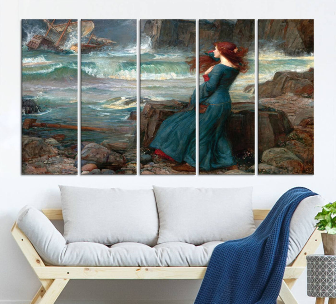 The Miranda by the Shore Wall Art Canvas Print depicts a woman in a blue dress standing by the sea, watching a shipwreck.