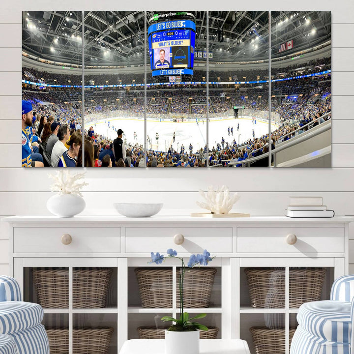 Wall art prints depicting the bustling scenes of the St. Louis Blues being cheered on by a full house at the Enterprise Center, beneath a large scoreboard.