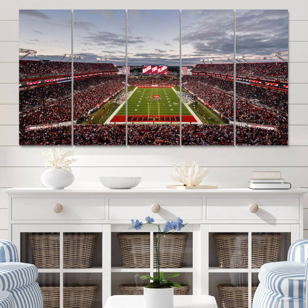 The wall art captures a stunning scene of Raymond James Stadium bathed in the warm hues of sunset. The sky, filled with clouds, provides a dramatic contrast to the vibrant lighting on the field, encapsulating the dynamic energy of a football game.