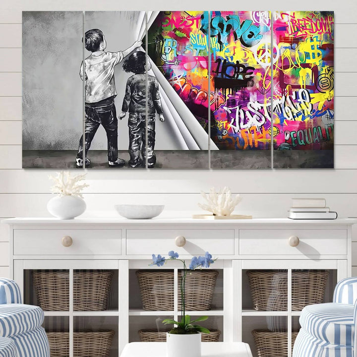 The Banksy Print - Street Art Canvas features a vibrant and bold image of two children lifting a curtain to reveal colorful graffiti. It's ready to hang, adding an urban modern decor vibe.