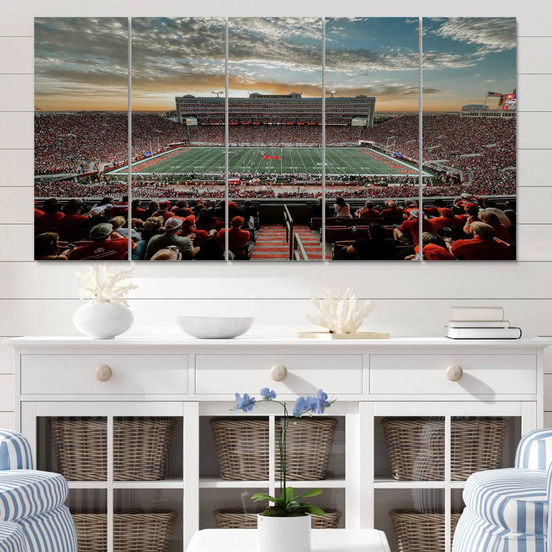 The living room features a stunning triptych of Lincoln Memorial Stadium wall art canvas print, celebrating the University of Nebraska Cornhuskers football team. This piece serves as captivating wall art, showcasing a gallery-quality finish.