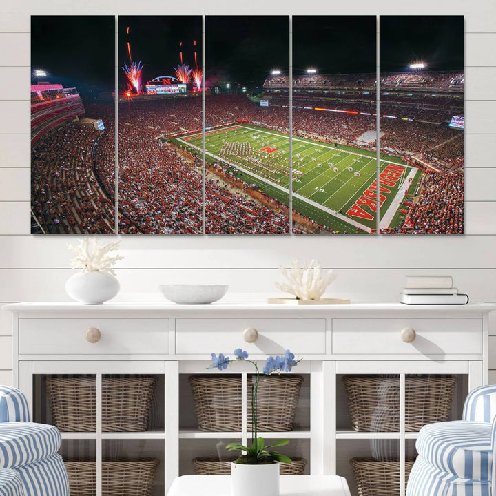 The University of Nebraska Cornhuskers Football Team Print, featuring Lincoln Memorial Stadium in a vibrant triptych canvas with fireworks above and a gallery-quality finish, is elegantly displayed.