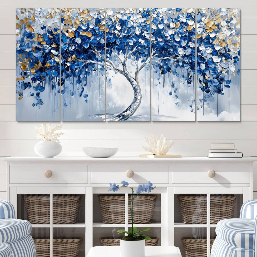 The Blue and Gold Abstract Tree Wall Art showcases a swirl trunk and features blue, silver, and gold leaves on a framed canvas print.