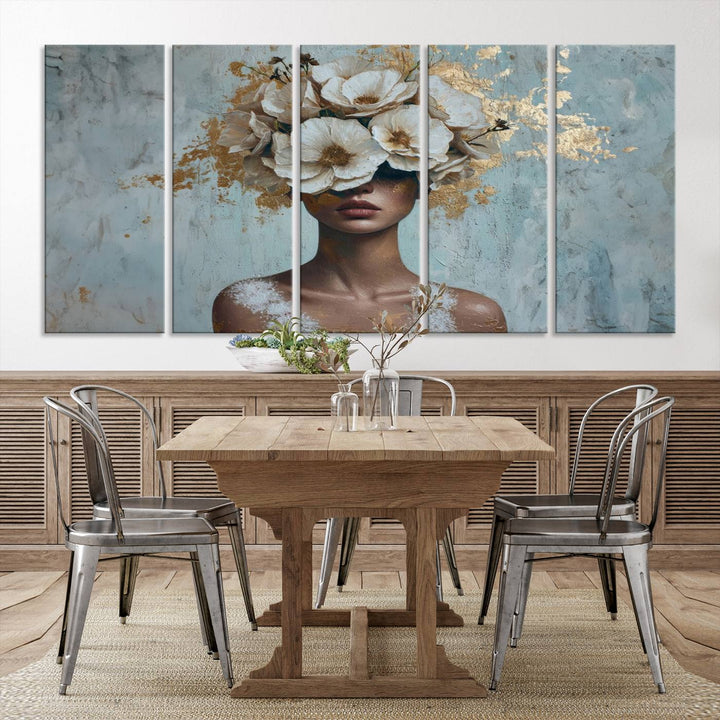 The Golden Petal Silhouette Woman Wall Art Canvas Print, a large 3-panel canvas with a textured gold floral design, serves as a luxurious centerpiece in modern glam settings. The artwork depicts a woman with flowers over her eyes against a textured background and hangs elegantly.