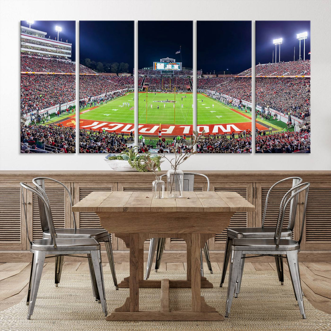 A NC State Wolfpack Football Team print of Carter-Finley Stadium at night features WOLFPACK illuminated brightly in the end zone grass.