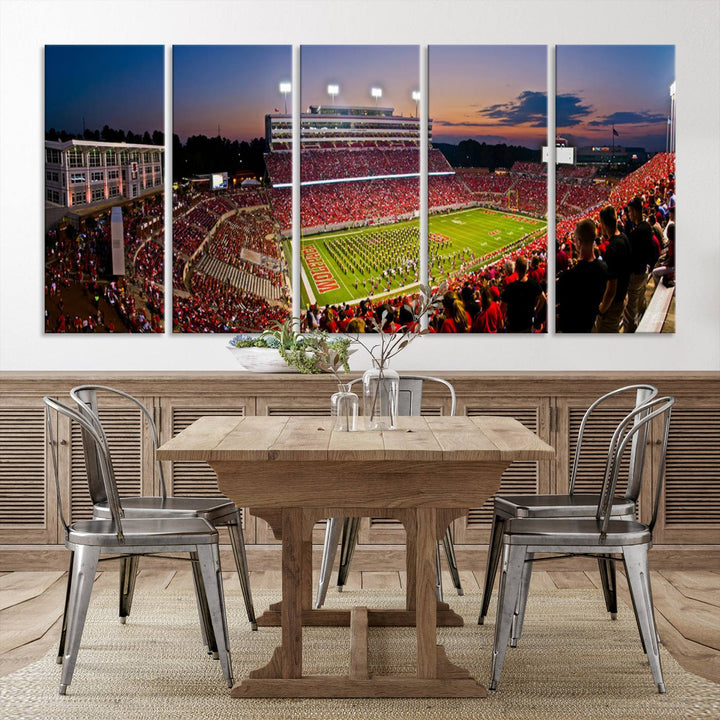 A print of a bustling Carter-Finley Stadium at dusk, featuring fans and a band, captures the essence of NC State Wolfpack football.