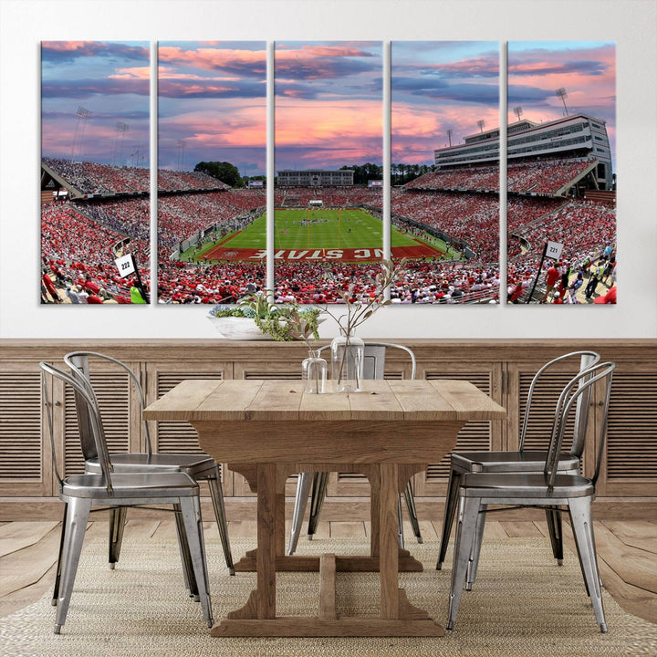 The wall art captures an NC State Wolfpack game under a vibrant sunset on triple canvas.