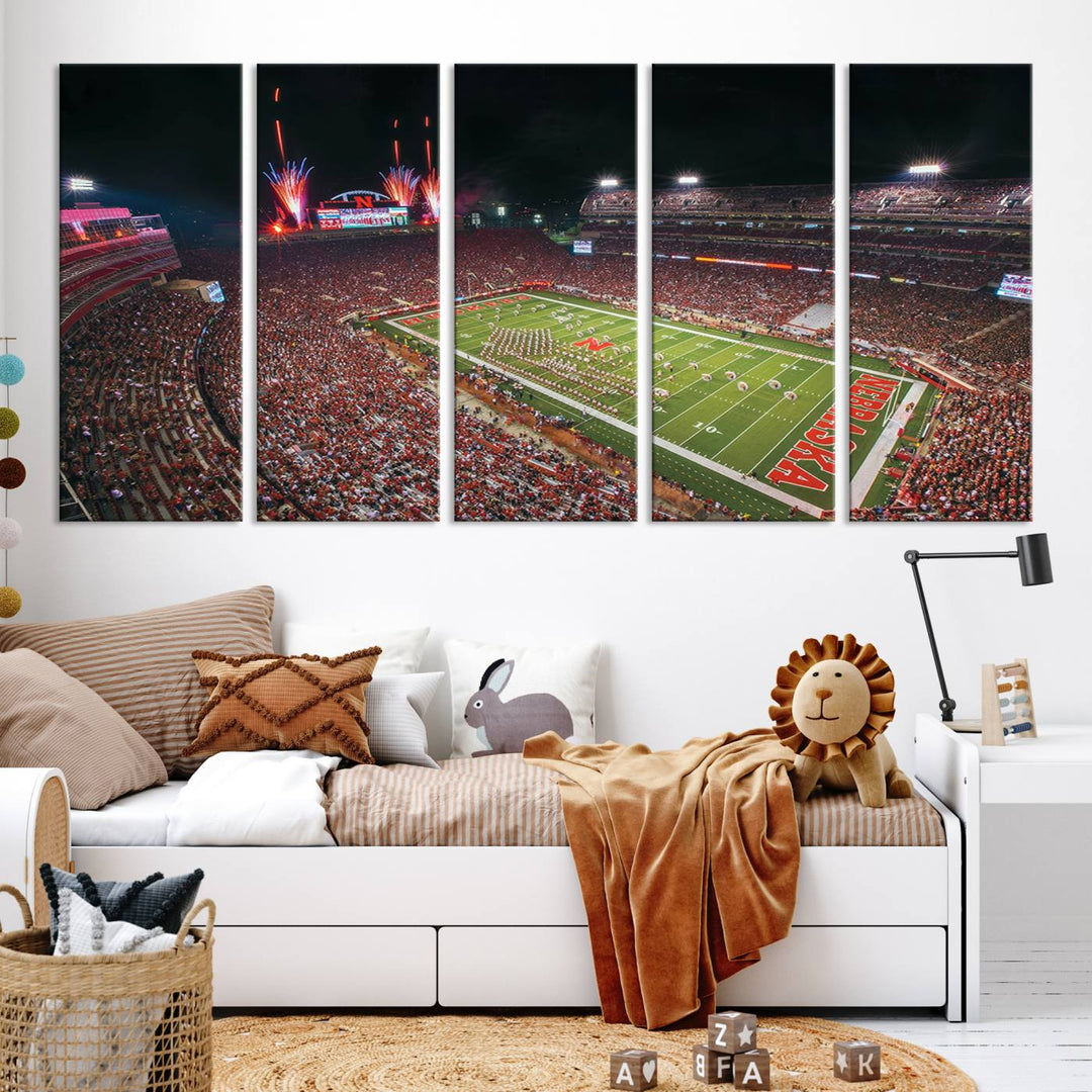 The University of Nebraska Cornhuskers Football Team Print, featuring Lincoln Memorial Stadium in a vibrant triptych canvas with fireworks above and a gallery-quality finish, is elegantly displayed.