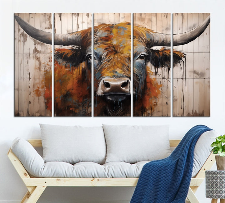 The "Abstract Bull Highland Cow Canvas Wall Art Print," displayed as a three-panel piece, adds vibrant rustic charm to a living room. Its depiction of a large, horned bull beautifully complements the elegance of modern farmhouse decor.