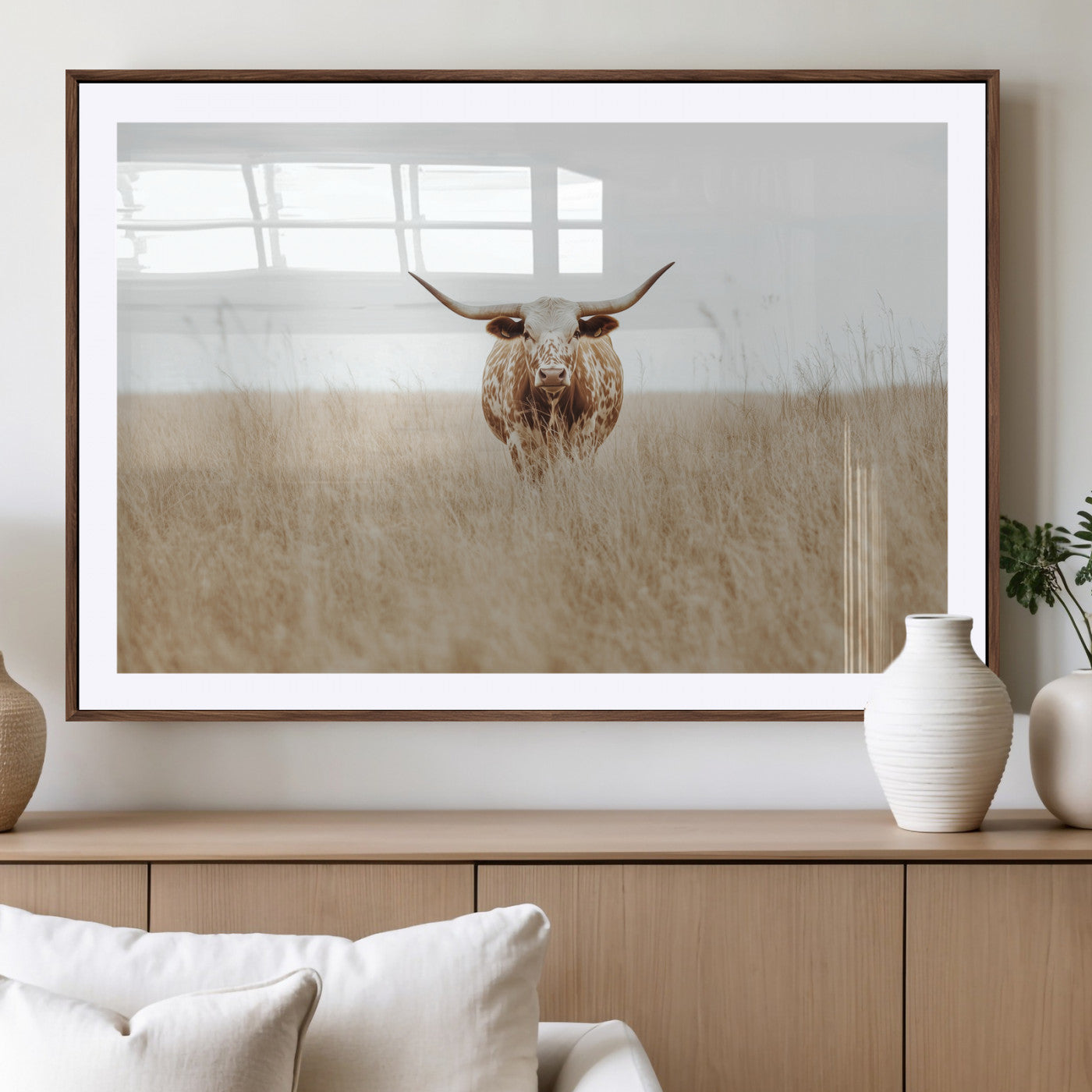 Texas Longhorn bull standing alone in dry grass with neutral tones, ideal for rustic western or cowboy-themed wall decor.