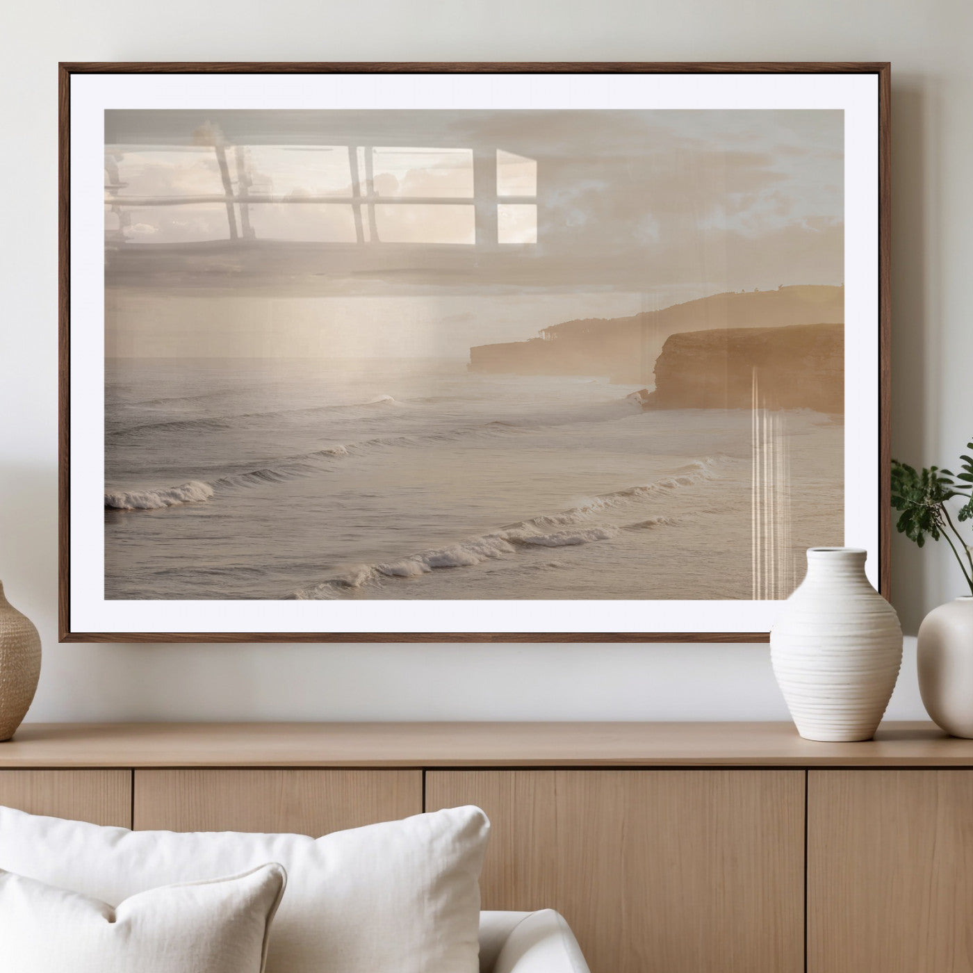 Golden hour seascape with misty cliffs and gentle waves rolling towards the shore, capturing a tranquil and warm coastal atmosphere.