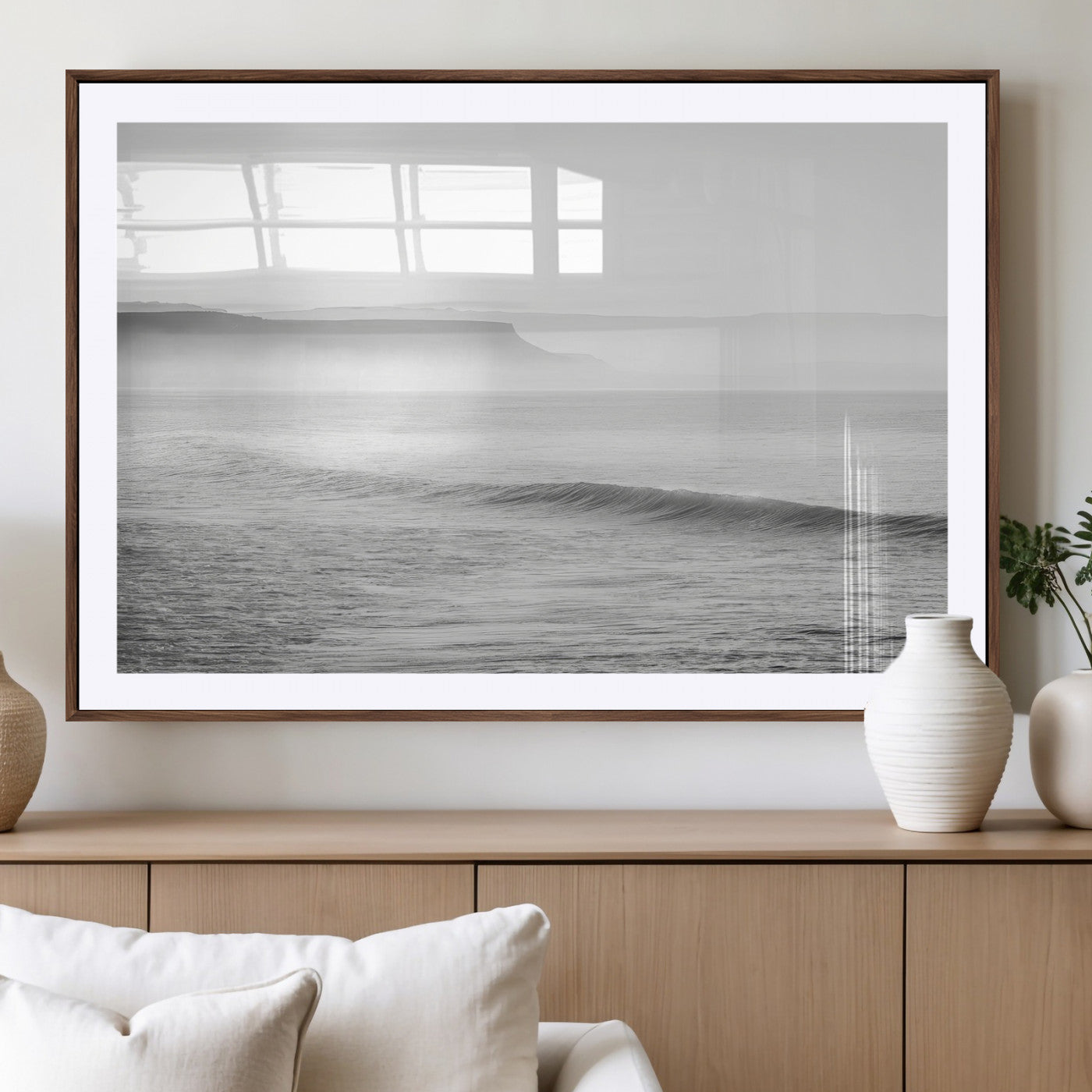A black and white minimalist seascape featuring soft rolling waves and misty distant cliffs, creating a serene and timeless coastal atmosphere.