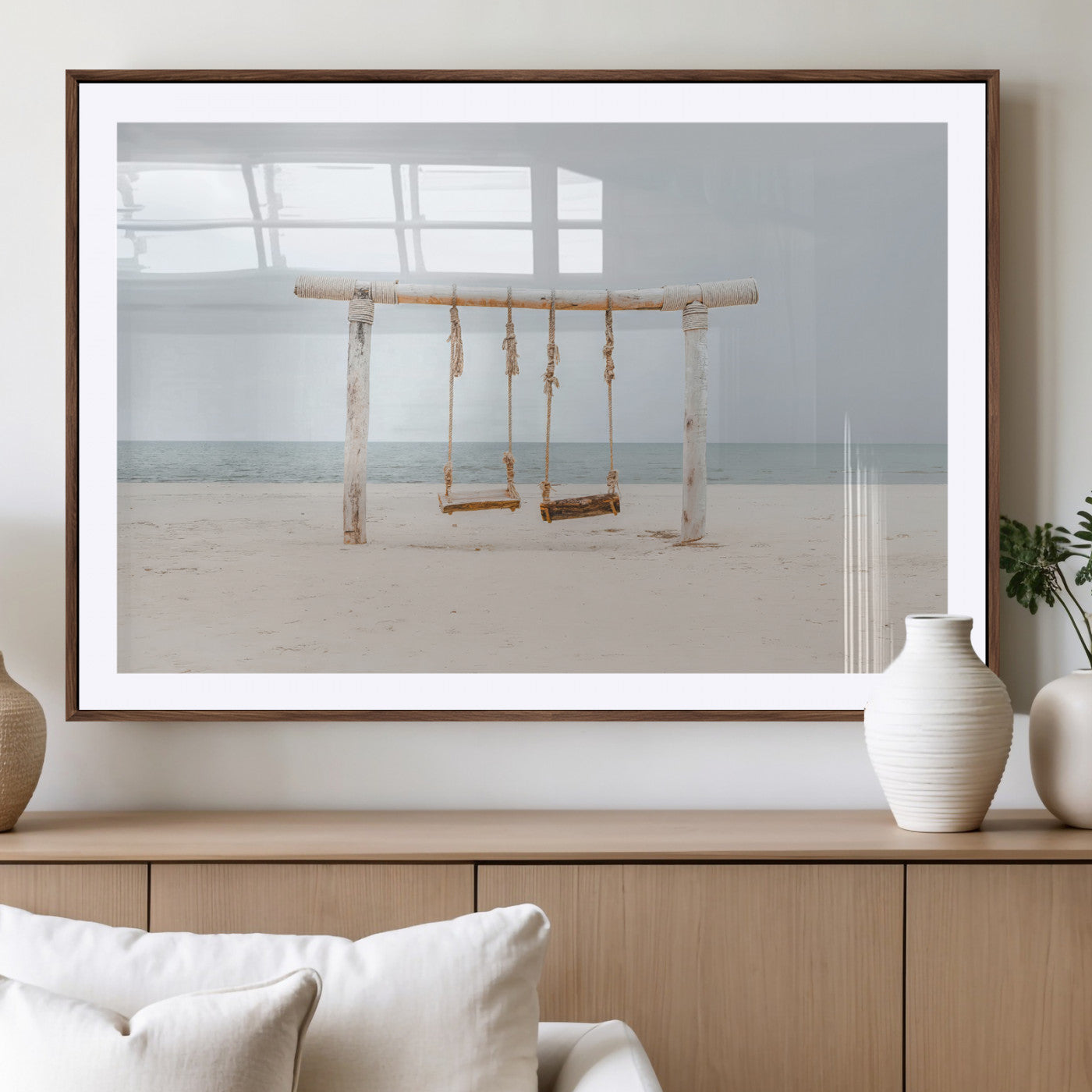 A rustic wooden beach swing stands on a serene sandy shore with an ocean horizon in the background, creating a tranquil and dreamy coastal escape.