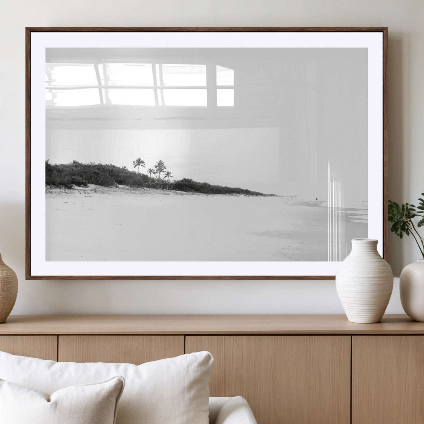 A black and white minimalist coastal scene with a vast open beach, distant palm trees, and a lone figure walking along the shoreline, evoking serenity and solitude.