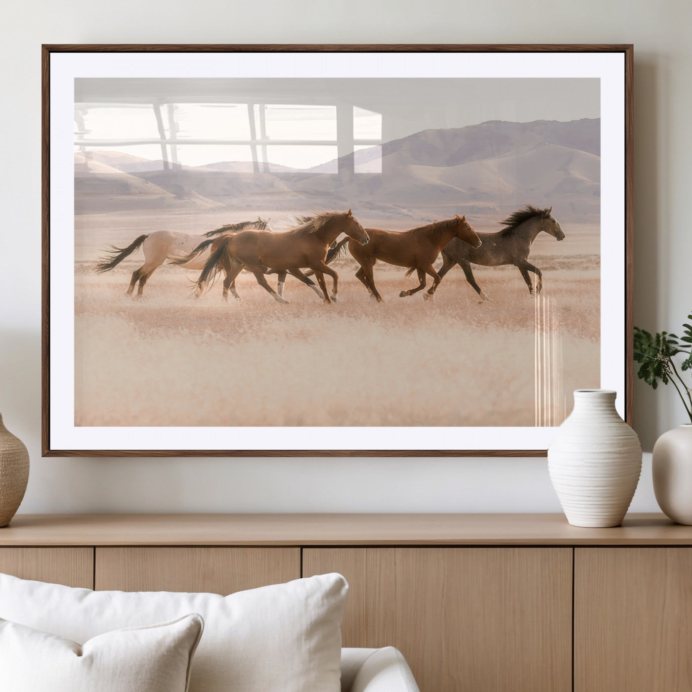 A herd of wild horses galloping through a sunlit desert plain with mountains in the background, perfect for rustic or western-themed wall decor.
