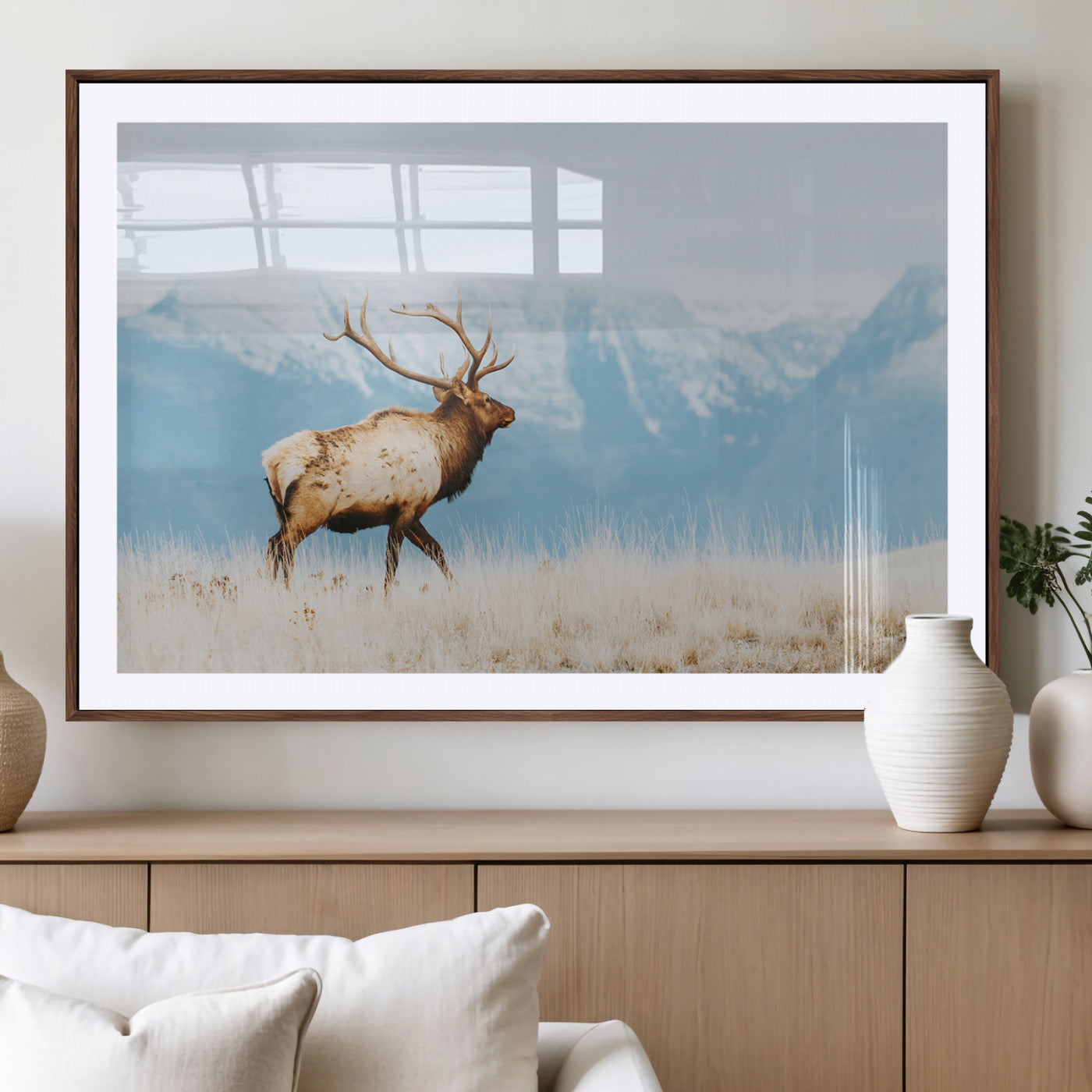 Majestic elk with antlers walking on golden grass, snowy mountains behind, perfect for rustic lodge or Scandinavian decor.