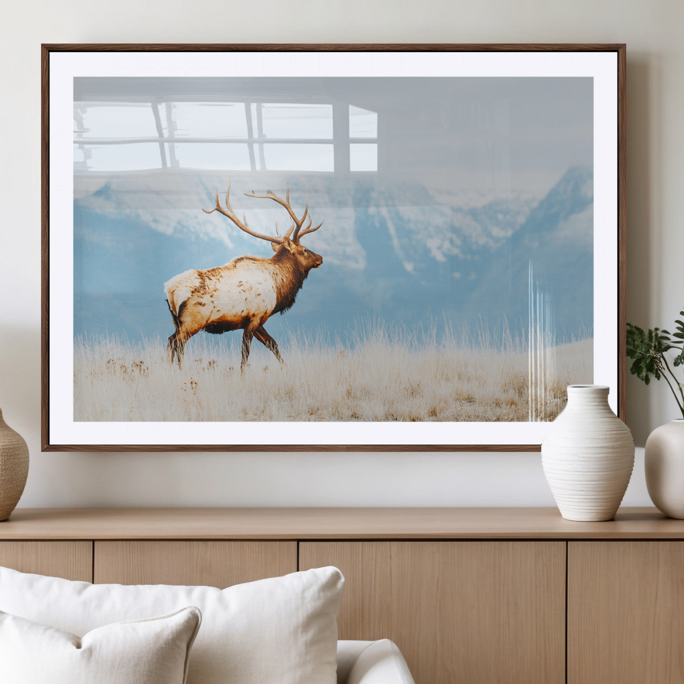 Majestic elk standing on dry grassland with snowy mountains in the background, ideal for rustic or lodge-inspired wall decor.