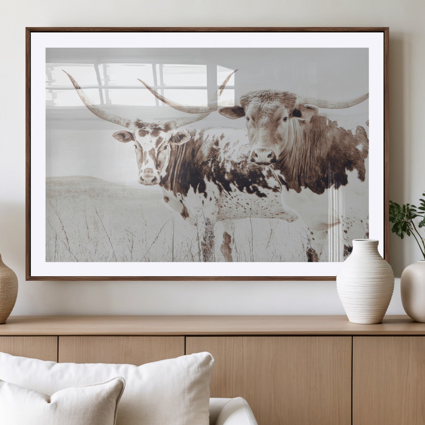Two longhorn cattle standing in a dry grassy field with neutral tones, creating a rustic and farmhouse-inspired Western aesthetic.
