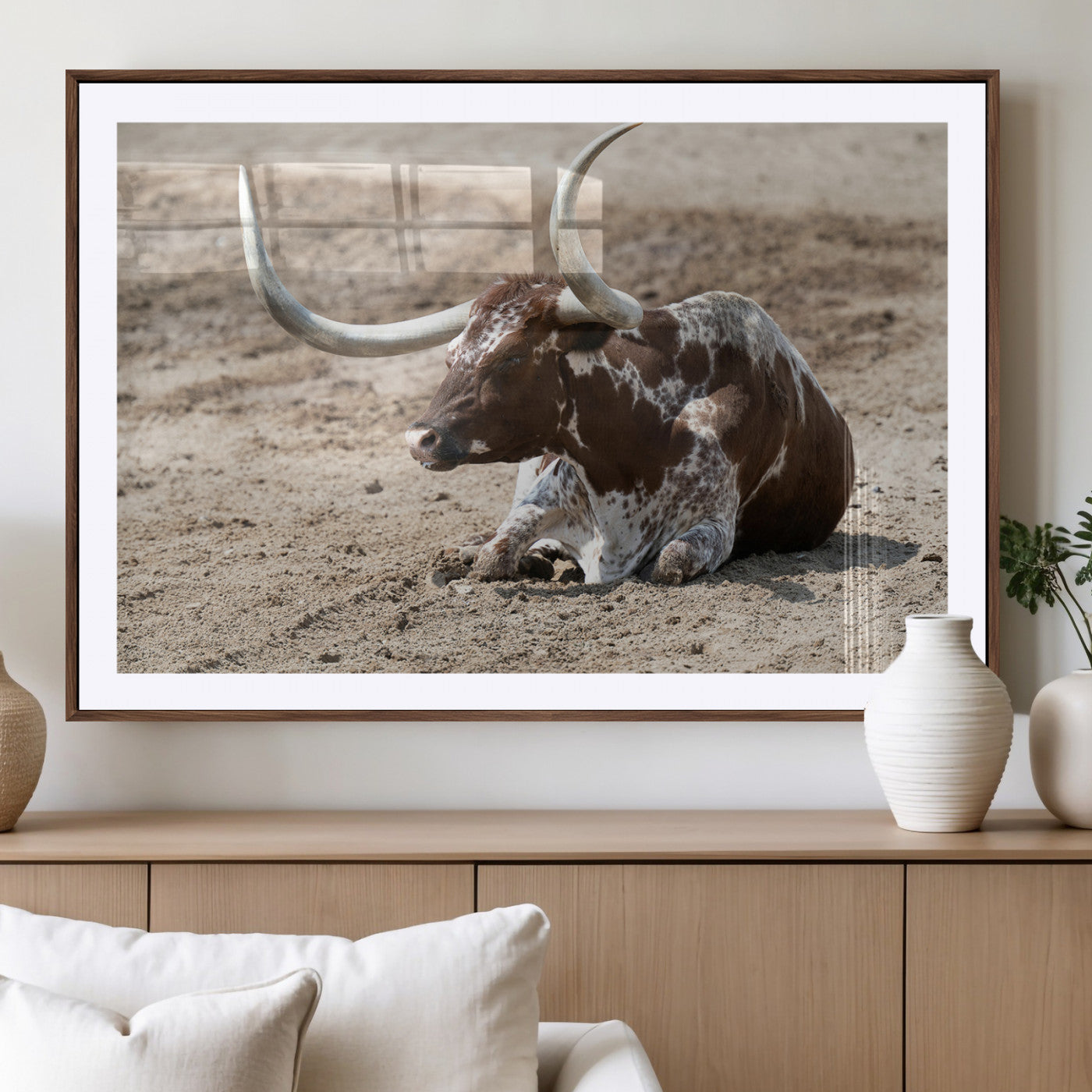 Texas Longhorn resting on sandy ground with large curved horns, capturing a rustic Western aesthetic perfect for farmhouse-style wall art.