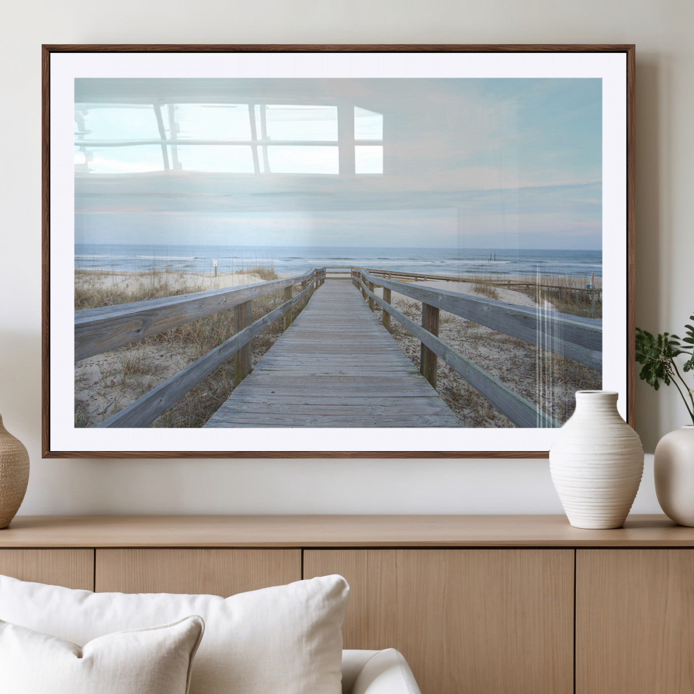 Wooden boardwalk leading to a peaceful beach with gentle ocean waves under a soft pastel sky, perfect for coastal and nautical home decor.