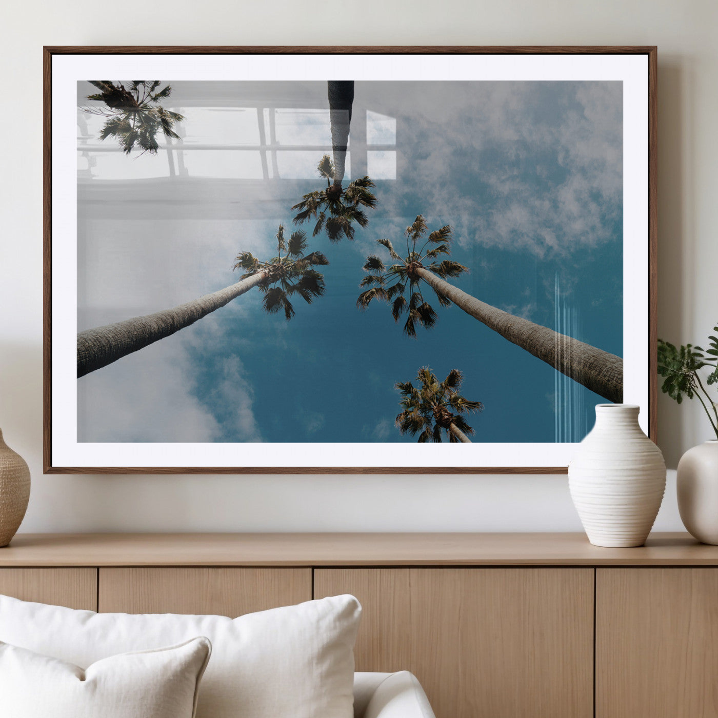 Looking up at tall palm trees against a bright blue sky with scattered clouds, creating a tropical and airy atmosphere for modern home decor.